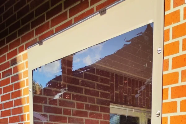 Kederplane mit Klarsichtfenster an Hauswand