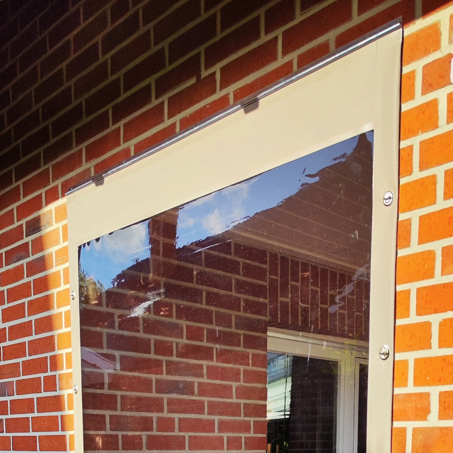 Kederplane mit Klarsichtfenster an Hauswand